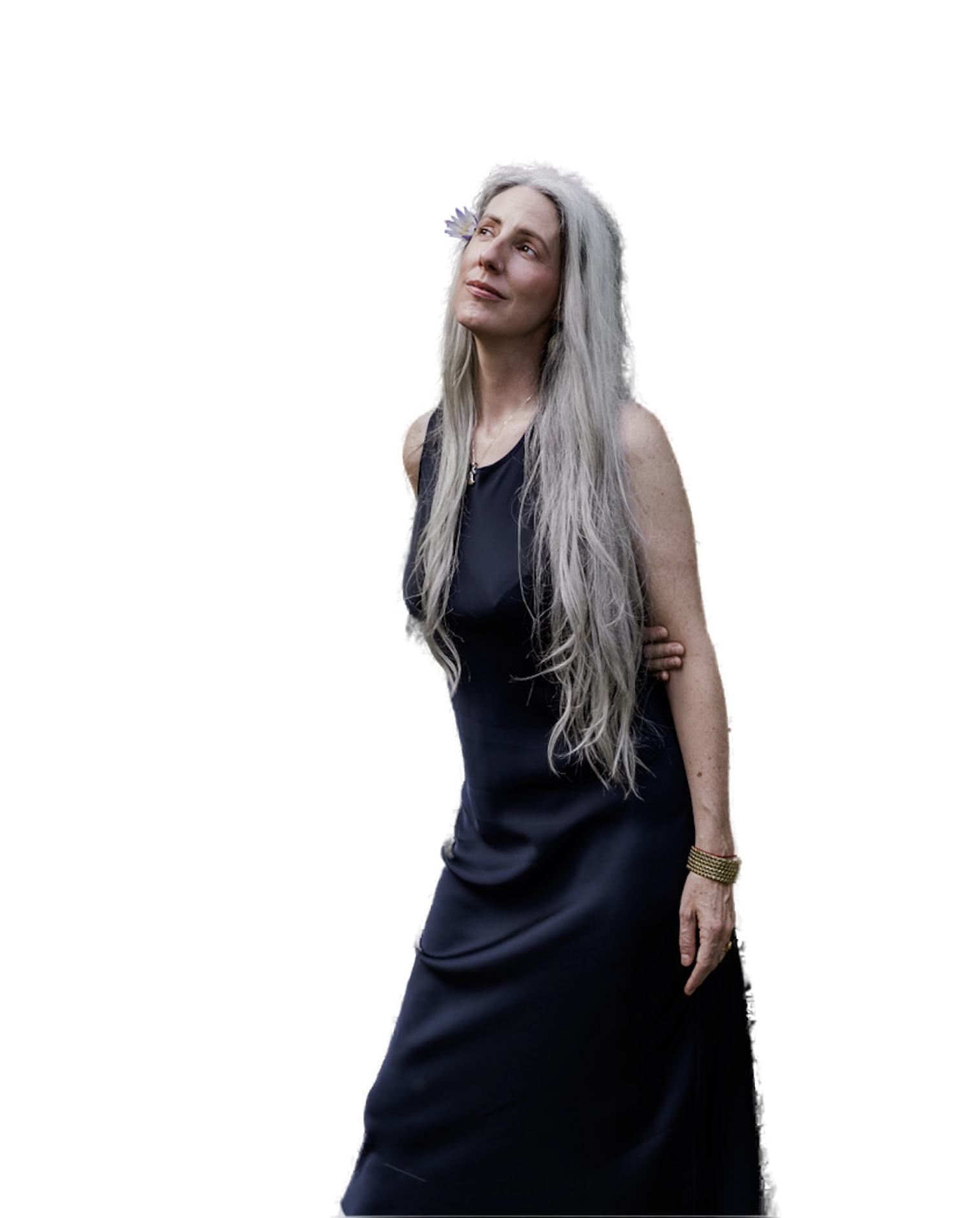 Helen Fehr with a lotus flower in her silver hair, gazing upward among tropical foliage